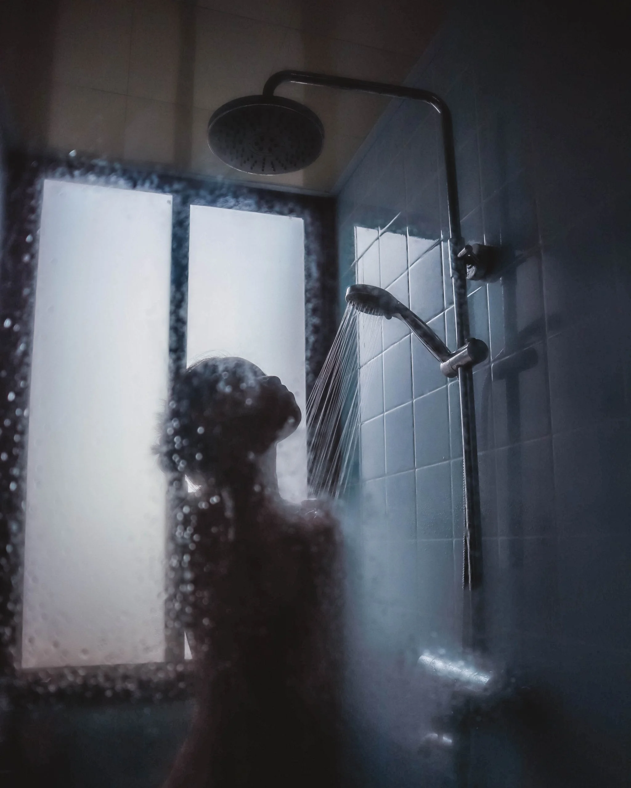 Een vrouw neemt een douche en de ruit is aangedamd door de warmte.