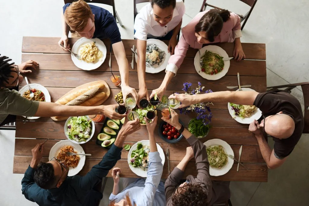 cohousing vs coliving : huit personnes mangent ensemble à une table