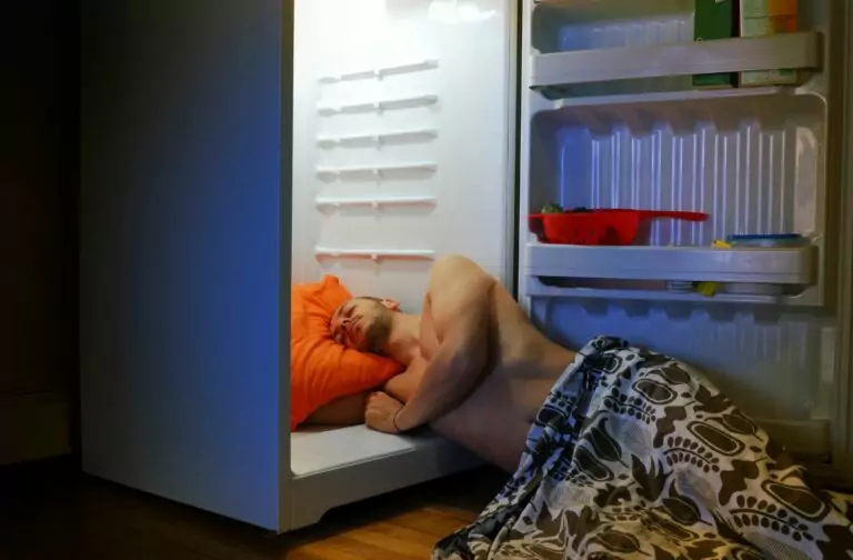 Man die slaapt in de ijskast omdat hij een warme slaapkamer heeft